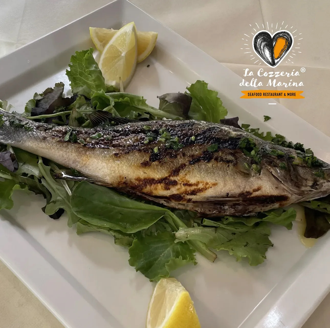 Pesce grigliato con verdure fresche e limone